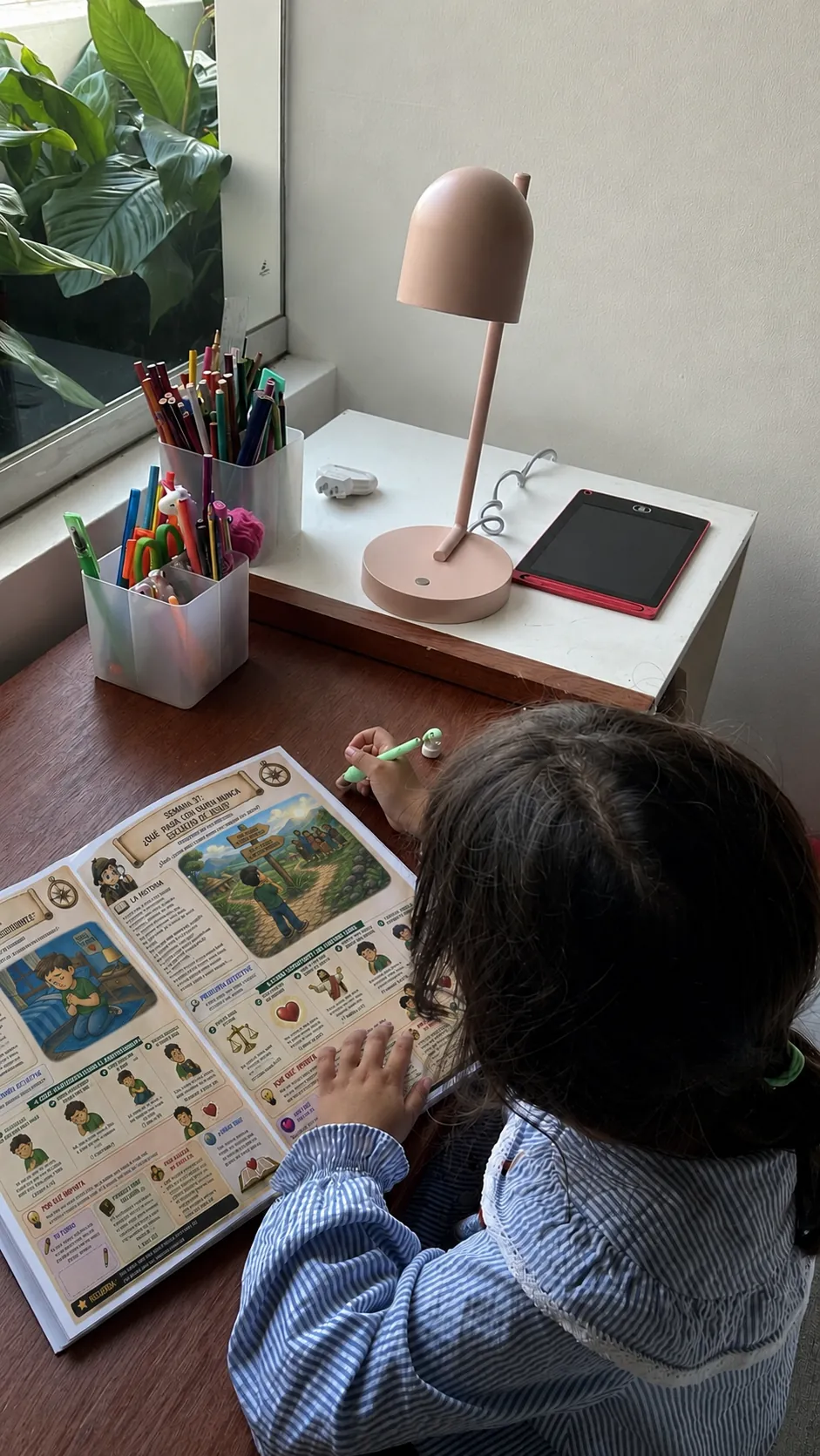 Child working through a weekly lesson at her desk